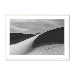 Black and white landscape photography print of smooth sand dunes under a moody sky, featuring subtle light and shadow contrasts, titled Guadalupe Dunes.