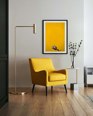 Yellow armchair in a modern living room with a yellow painting on the wall.